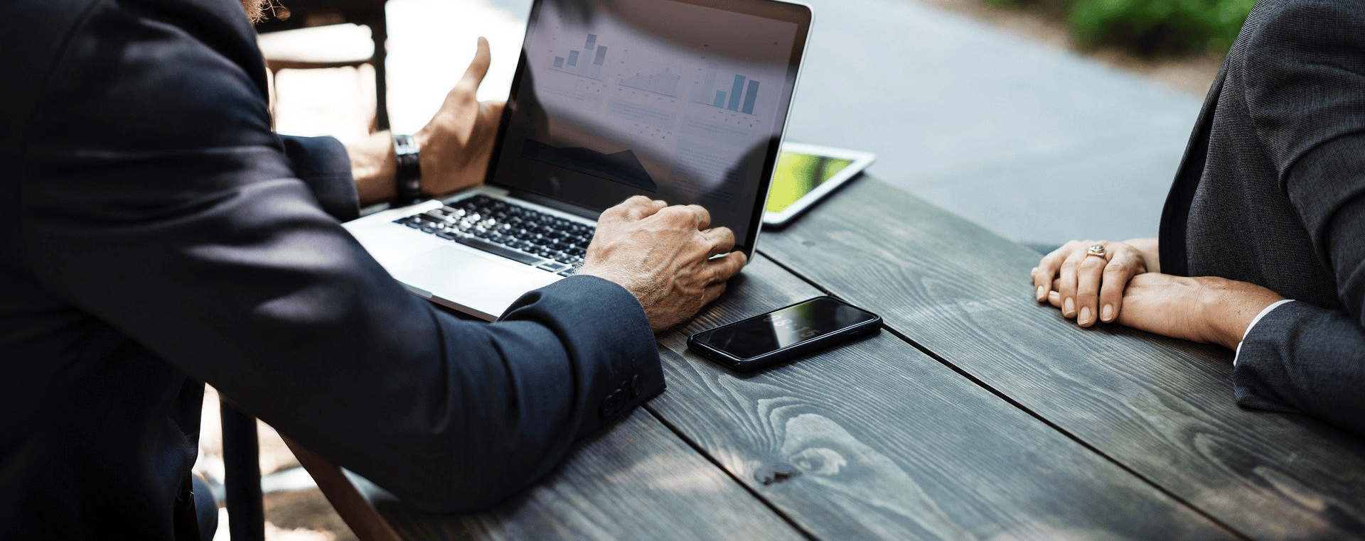  Two people having a discussion while looking at a laptop